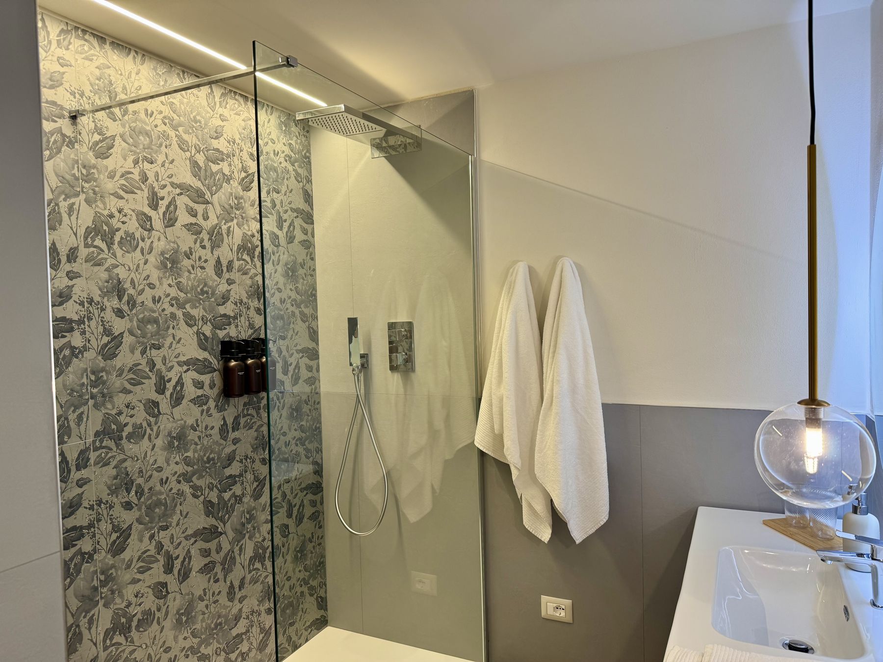 La doccia walk-in con soffione e piastrelle a motivi floreali nel bagno della Camera Aria