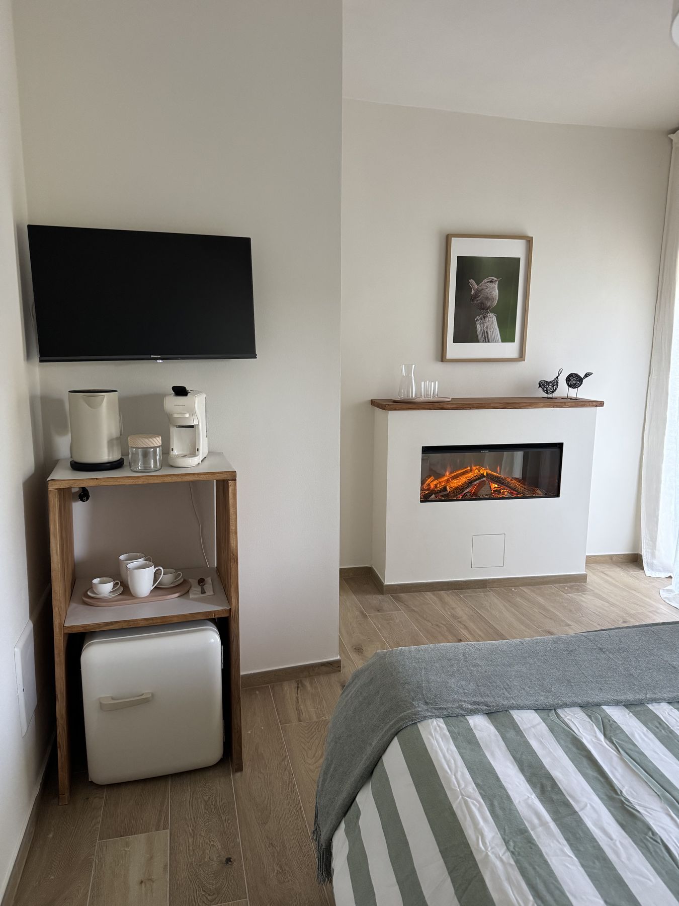 La coffee station con macchina da caffè e frigobar, il camino elettrico e la smart TV della Camera Bosco