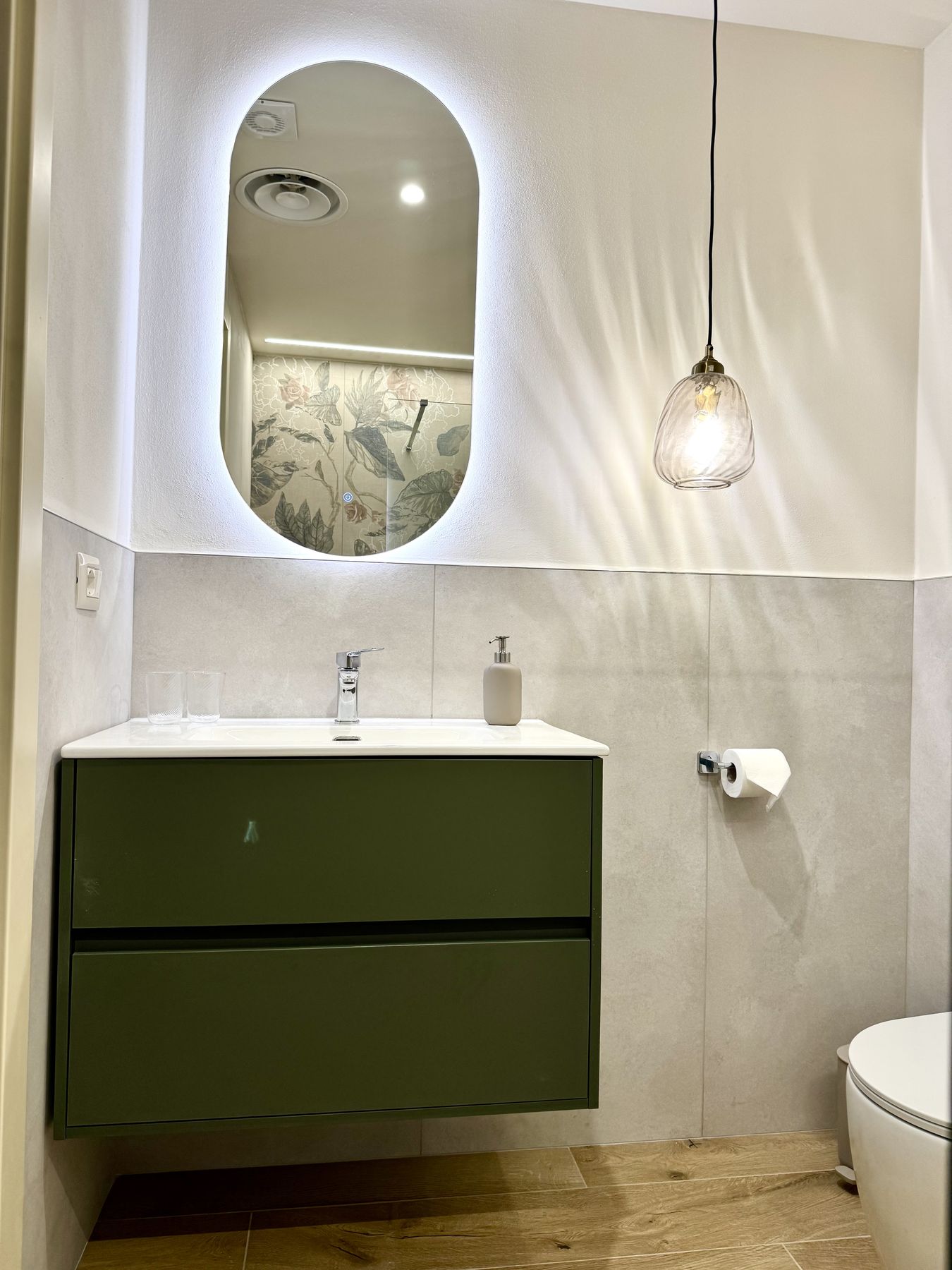 Il mobile lavabo verde con specchio ovale retroilluminato nel bagno della Camera Bosco